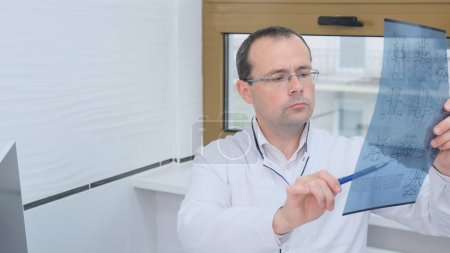 Téléchargez les photos : Un médecin masculin examine les résultats d'un scanner du cerveau - en image libre de droit