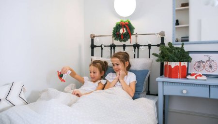Foto de Dos niñas juegan en la cama en la guardería - Imagen libre de derechos