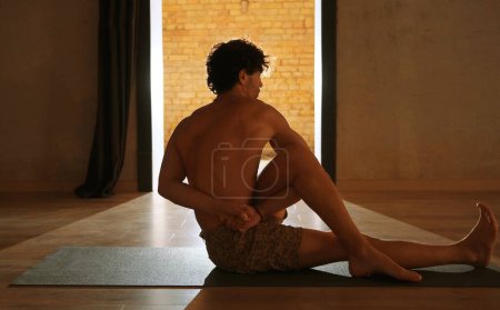 Photo for A young and athletic man does yoga and performs asanas. - Royalty Free Image