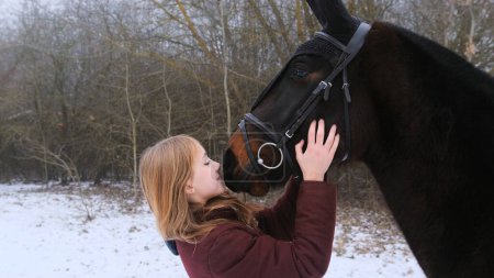 Foto de Una joven hermosa chica abraza a un caballo en la naturaleza en la niebla - Imagen libre de derechos