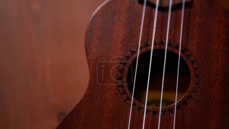 A charming ukulele gracing a wooden table, inviting musical moments with its acoustic allure and strings that resonate with a touch of Hawaiian serenity