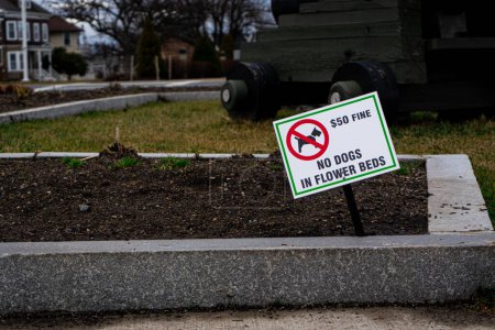 Foto de Un letrero de 'No Dogs on Garden' con una tarifa, enfatizando la tranquilidad sin mascotas y las regulaciones de espacio verde - Imagen libre de derechos