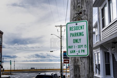 Photo for "Resident Parking Only" sign with specific times stands sentinel, a visual testament to regulated city living - Royalty Free Image