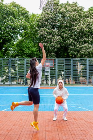 Photo for Concept of sports, hobbies and healthy lifestyle. Young people playing basketball on playground outdoors - Royalty Free Image