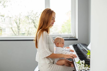 Téléchargez les photos : Mère et fille jouent du piano. Développement du bébé. Expérience sensorielle. Développement du cerveau. Les premières années. - en image libre de droit