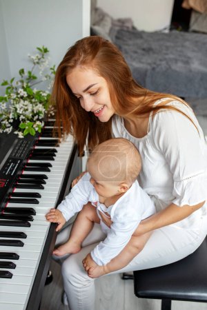 Téléchargez les photos : Mère et fille jouent du piano. Développement du bébé. Expérience sensorielle. Développement du cerveau. Les premières années. - en image libre de droit