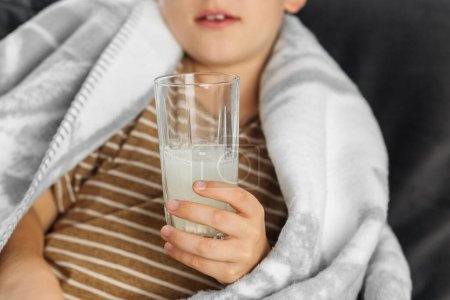 Ein Glas Wasser mit Vitamin C in Kinderhänden. Saisonale Erkältung.