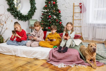 Photo for Group children playing or chatting on smartphones in living room. Internet concept. - Royalty Free Image
