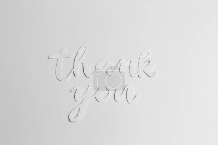 Minimalist thank you message crafted in stylish cursive font isolated on clean white backdrop.