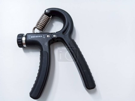 Close up Black Adjustable Hand Grip Strengthener Isolated On White Background. Hand exercise gripper for Athletes and Hand Rehabilitation Exercising
