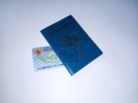 Passeport vert République d'Indonésie et carte d'identité indonésienne à la main humaine sur fond blanc.