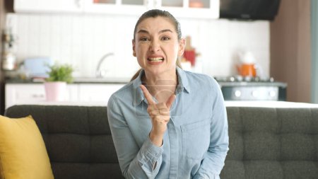 Photo for Young woman arguing and shouting angrily reacts to her lover or husband. Hysterical angry young woman crying crying looking at camera. She is crazy, angry and yelling and fighting at the other person. - Royalty Free Image