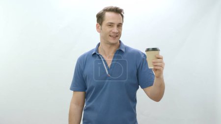 Photo for Studio portrait of young man holding paper coffee mug. Smiling positive man holding paper cup on white background looking at empty advertising space. - Royalty Free Image