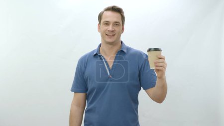 Photo for Studio portrait of young man holding paper coffee mug. Smiling positive man holding paper cup on white background smiling at camera. Portrait of human into coffee. - Royalty Free Image