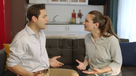 Photo for Young couple arguing, fighting. Scene of violence and fight between couples.Young married people fighting, arguing, shouting at each other in living room. - Royalty Free Image