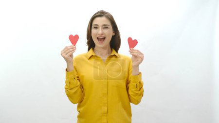 Photo for Smiling young woman isolated on white background dancing with two paper hearts she made. Portrait of a smiling woman with two paper hearts. Valentine's or mother's day celebration. - Royalty Free Image
