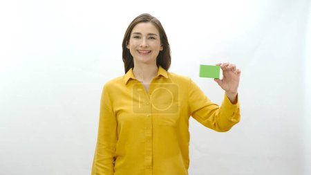 Photo for Young woman isolated on white background holding something green, showing a product, smiling and cheerful.Creative people can replace the green box with any product they want. - Royalty Free Image