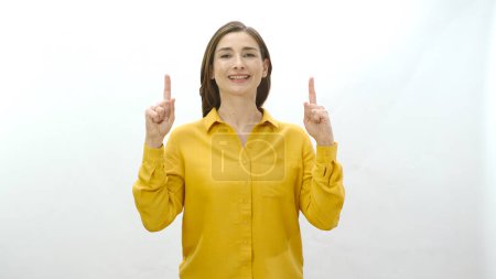 Photo for Woman pointing to the top of the screen, finger pointing at the advertising space above the screen, isolated on a white background. Creative people can put anything they want where they show. - Royalty Free Image