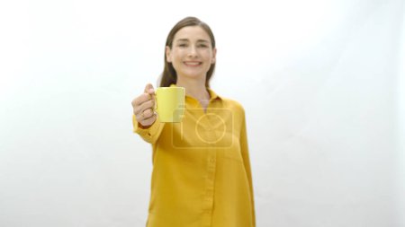Foto de Retrato de carácter de una joven bebiendo una taza de café, té negro o verde. Mujer joven y saludable apuntando a la cámara con una taza de café o té aislado sobre fondo blanco. - Imagen libre de derechos