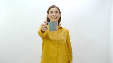 Charakterporträt einer jungen Frau, die eine Tasse Kaffee, schwarzen oder grünen Tee trinkt. Junge gesunde Frau zeigt auf Kamera mit Tasse Kaffee oder Tee isoliert auf weißem Hintergrund.
