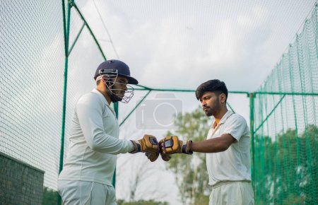 Téléchargez les photos : Deux joueurs de cricket se donnent un coup de poing après discussion. Photo de haute qualité. Concept de travail d'équipe, esprit sportif. - en image libre de droit