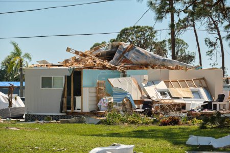Photo for Severely damaged house after hurricane Ian in Florida mobile home residential area. Consequences of natural disaster. - Royalty Free Image