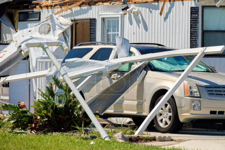 Foto de Destruido por el huracán Ian casa suburbana y coche dañado en Florida zona residencial de casas móviles. Consecuencias del desastre natural. - Imagen libre de derechos