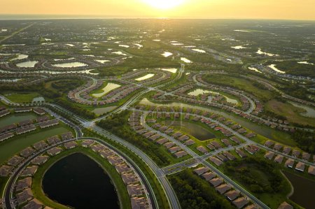 Foto de Vista aérea de casas familiares bien ubicadas con estanques de retención para evitar inundaciones en el área suburbana cerrada de Florida. Desarrollo inmobiliario en suburbios americanos. - Imagen libre de derechos