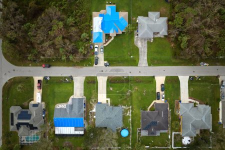 Téléchargez les photos : Vue aérienne du toit endommagé de la maison de l'ouragan Ian recouvert d'une bâche de protection bleue contre les fuites d'eau de pluie jusqu'au remplacement des bardeaux d'asphalte. - en image libre de droit