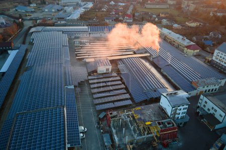 Téléchargez les photos : Vue aérienne de la centrale solaire avec panneaux photovoltaïques bleus montés sur le toit du bâtiment industriel pour produire de l'électricité écologique verte. Production de concept d'énergie durable. - en image libre de droit
