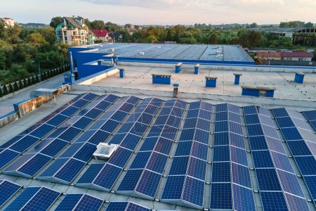 Luftaufnahme blauer Photovoltaik-Sonnenkollektoren auf dem Dach eines Industriegebäudes zur Erzeugung grünen ökologischen Stroms. Produktion eines nachhaltigen Energiekonzepts.