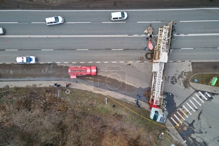 Vue aérienne de l'accident de la route avec camion renversé bloquant la circulation.