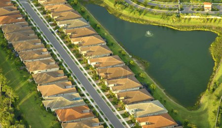 Photo for Aerial view of tightly packed homes in Florida closed living clubs with lake water in the middle. Family houses as example of real estate development in american suburbs. - Royalty Free Image