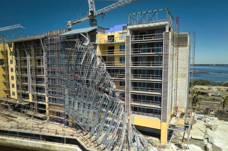 Aerial view of ruined by hurricane Ian construction scaffolding on high apartment building site in Port Charlotte, USA.