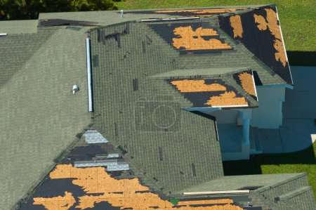 Téléchargez les photos : Toit de la maison endommagé par le vent avec des bardeaux d'asphalte manquants après l'ouragan Ian en Floride. Réparation du concept de toit de la maison. - en image libre de droit