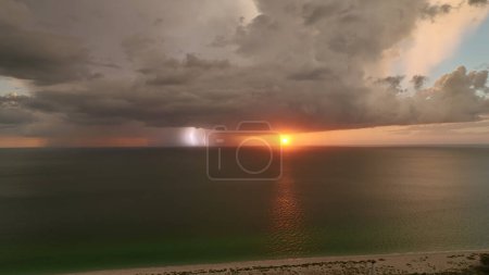 Téléchargez les photos : Nuages orageux foncés se formant sur un ciel sombre pendant la saison des pluies abondantes sur la surface du baech marin en soirée. - en image libre de droit