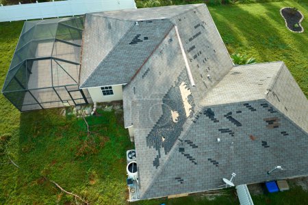Téléchargez les photos : Toit de la maison endommagé par le vent avec des bardeaux d'asphalte manquants après l'ouragan Ian en Floride. Réparation du concept de toit de la maison. - en image libre de droit