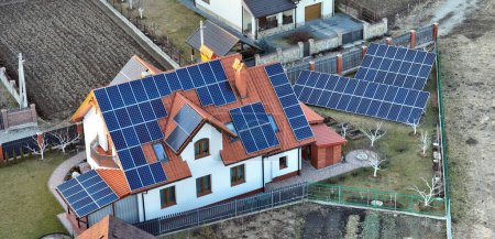 Photo for Private home roof covered with solar photovoltaic panels for generating of clean ecological electric energy in suburban rural town area. Concept of autonomous house. - Royalty Free Image