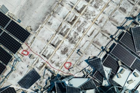 Foto de Paneles solares fotovoltaicos destruidos por los vientos del huracán Ian montados en el techo de un edificio industrial para producir electricidad ecológica verde. Consecuencias del desastre natural. - Imagen libre de derechos