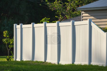 Photo for White plastic fence for back yard protection and privacy. - Royalty Free Image