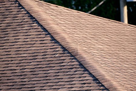 Foto de Closeup of house roof top covered with asphalt or bitumen shingles. Waterproofing of new building. - Imagen libre de derechos