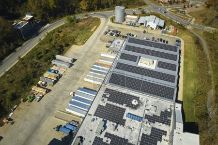 Téléchargez les photos : Vue aérienne de la centrale solaire avec panneaux photovoltaïques bleus montés sur le toit du bâtiment industriel pour produire de l'électricité écologique verte. Production de concept d'énergie durable. - en image libre de droit