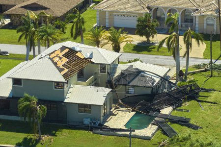 Hurricane Ian destroyed swimming pool lanai enclosure on house yard in Florida residential area. Natural disaster and its consequences.