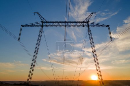 Téléchargez les photos : Tour haute tension avec lignes électriques au coucher du soleil. Transport d'électricité. - en image libre de droit