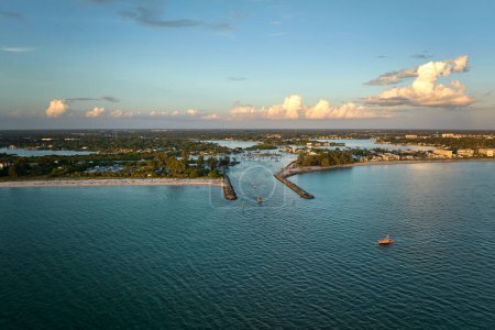 Téléchargez les photos : Vue aérienne de la côte de la mer près de Venise, Floride avec des yachts blancs au coucher du soleil flottant sur les vagues de la mer. Jetée nord et sud sur la plage de Nokomis. Loisirs en bateau à moteur à la surface de l'océan. - en image libre de droit