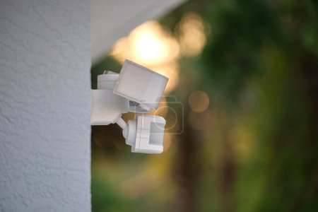 Téléchargez les photos : Capteur de mouvement avec détecteur de lumière monté sur le mur extérieur de la maison privée dans le cadre du système de sécurité. - en image libre de droit