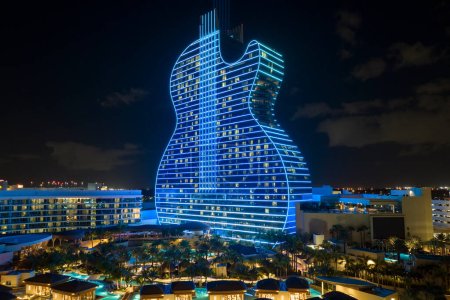 Luftaufnahme des gitarrenförmigen Seminole Hard Rock Hotel und Casino Struktur beleuchtet mit hellen neonfarbenen Lichtern in Hollywood, Florida.