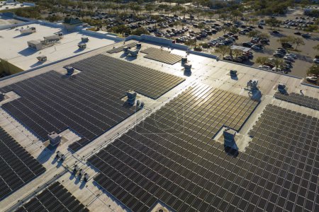 Photo for Aerial view of blue photovoltaic solar panels mounted on shopping mall building roof for producing green ecological electricity. Production of sustainable energy concept. - Royalty Free Image