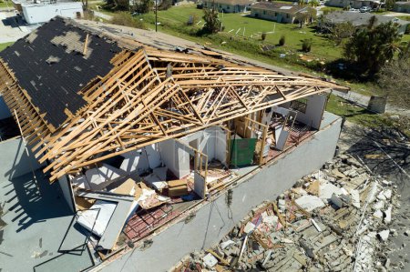 Hurricane Ian destroyed house roof and walls in Florida residential area. Natural disaster and its consequences.