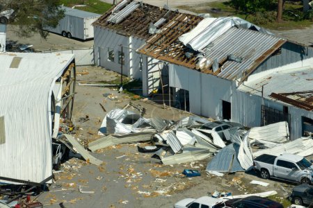 Hurricane strong wind destroyed suburban house roofs in Florida mobile home residential area. Consequences of natural disaster.